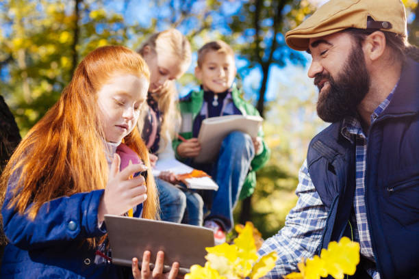 istock Cute red haired girl looking into her copybook 1067174764