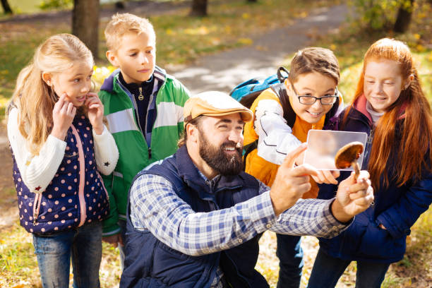 istock Joyful cute children standing behind their teacher 1067177130