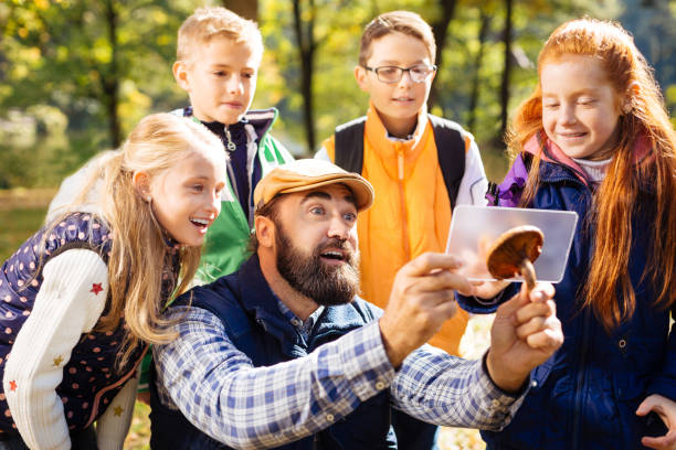 Joyful bearded man being surrounded by his pupils
