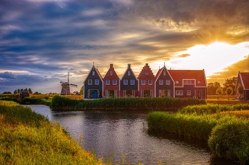 A traditional Dutch village with colorful, old wooden houses, vintage windmills and canals