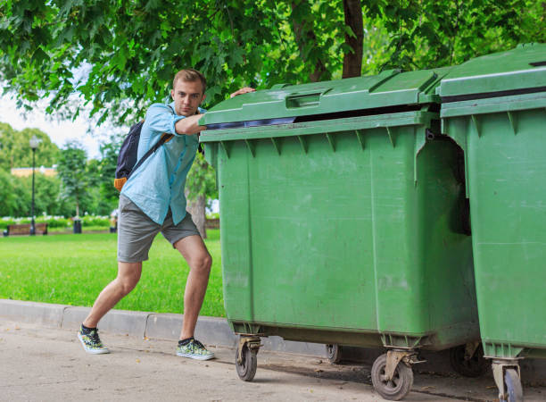 istock Man pushing a green garbage cans in the park 1067184492