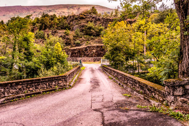 Old bridge over the river Ax-les-thermes near the village with the same name in the French Pyrenees and neighboring Andorra. Ariege France
