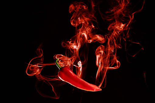 Hot chili pepper with red hot smoke