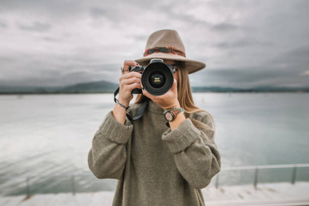 istock Young woman taking a picture with a modern DSLR camera 1067196320