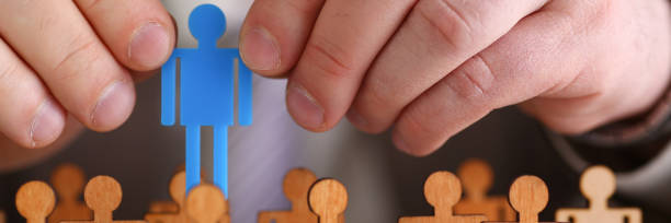 istock Man arm in suit take little plastic toy figure 1067203604