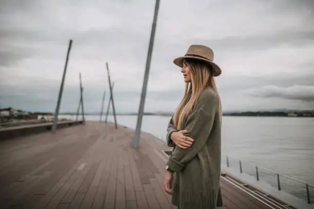 Photo of Young woman portrait with hat by the sea