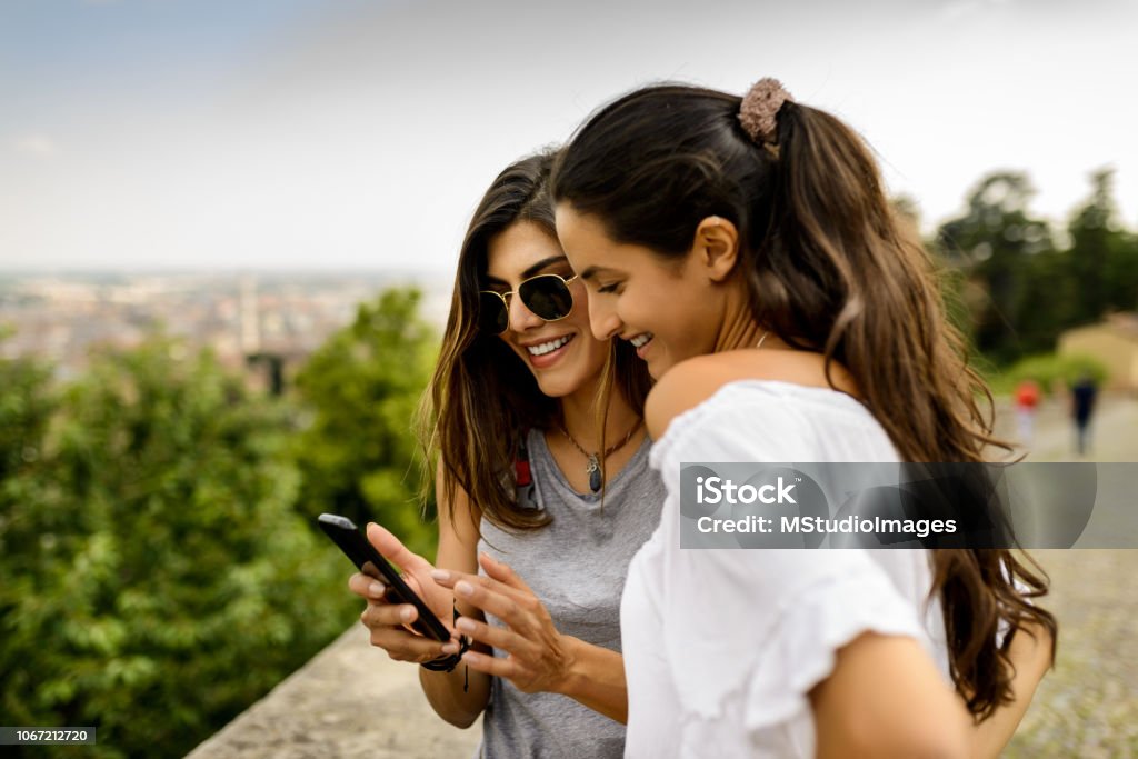 Using mobile phone. Two tourist women using mobile phone at the nature Friendship Stock Photo