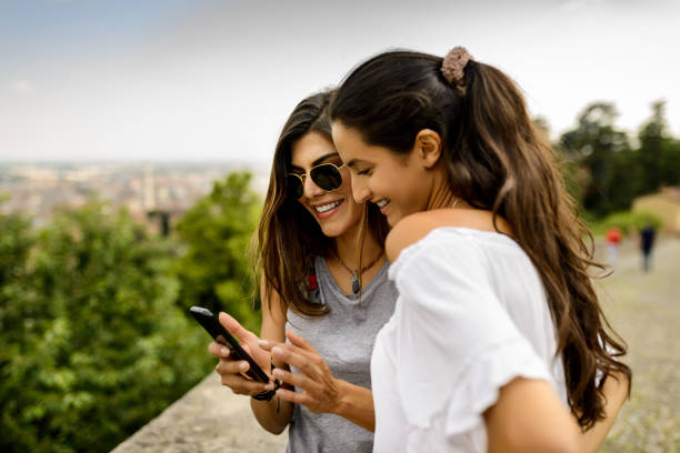 Using mobile phone. Two tourist women using mobile phone at the nature latin american and hispanic culture photos stock pictures, royalty-free photos & images