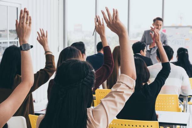 istock Audience raising hands up while businessman is speaking in training at the office. 1067220998