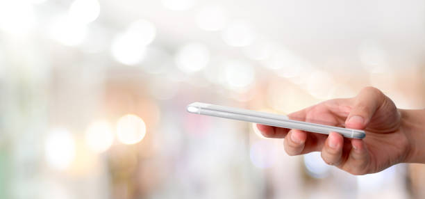istock Hand using smart phone over blur bokeh light background, business and technology, internet of things concept 1067231456