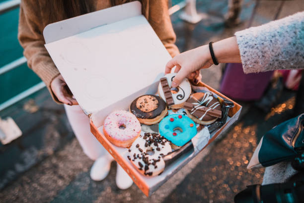 young woman with a box full of doughnuts - cake pick imagens e fotografias de stock