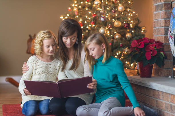 istock Mother reads to her daughters under the Christmas tree 1067236442