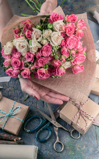 istock Work process of florist. Female hands making wedding bouquet on a dark table. Small business concept. 1067243348