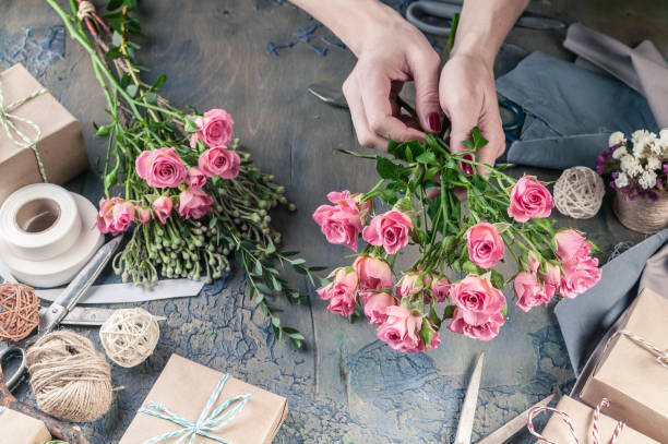 istock Work process of florist. Female hands making wedding bouquet on a dark table. Small business concept. 1067243356