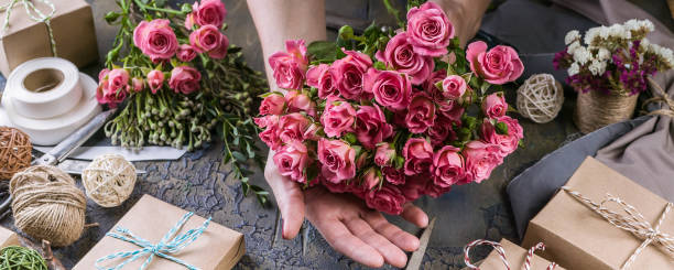 istock Web banner. Small business concept. Work process of florist. Female hands making wedding bouquet on a dark table 1067243382