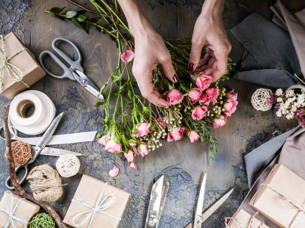 istock Work process of florist. Female hands making wedding bouquet on a dark table. Small business concept. 1067243384