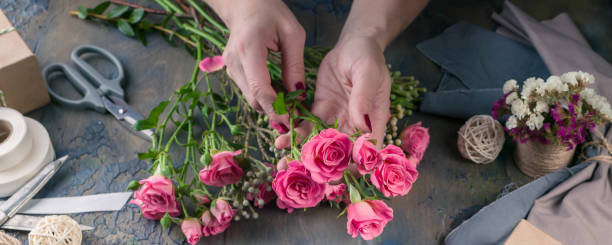 istock Web banner. Small business concept. Work process of florist. Female hands making wedding bouquet on a dark table 1067243394