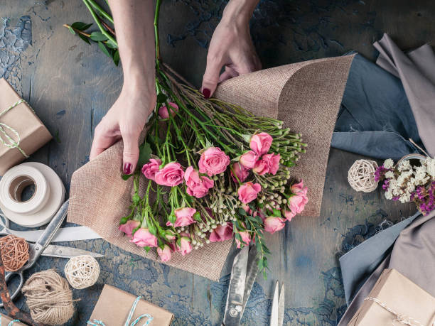 istock Work process of florist. Female hands making wedding bouquet on a dark table. Small business concept. 1067243404