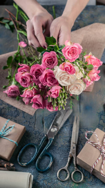 istock Work process of florist. Female hands making wedding bouquet on a dark table. Small business concept. 1067243420