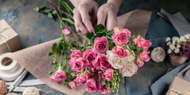 Web banner. Small business concept. Work process of florist. Female hands making wedding bouquet on a dark table