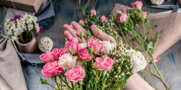 istock Web banner. Small business concept. Work process of florist. Female hands making wedding bouquet on a dark table 1067243472
