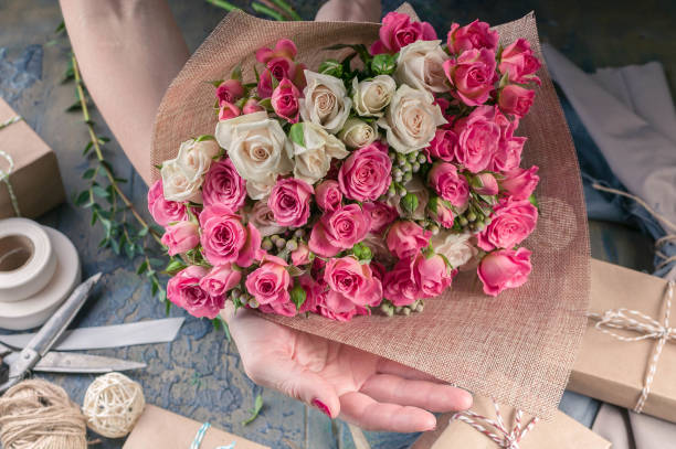 istock Female hands making wedding bouquet on a dark table. Small business concept. Work process of florist. 1067243496