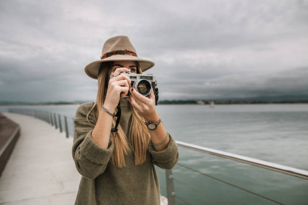 istock Young woman using a vintage camera 1067243926