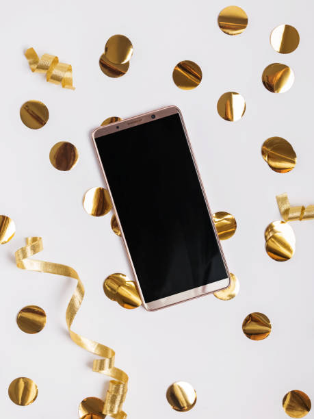 istock Phone with blank screen lying on the table with golden color decor and tinsel. 1067246586