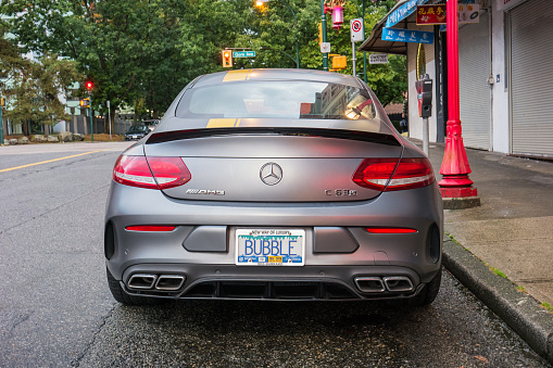 A Mercedes C 63 S AMG coupe luxury sports car is parked on a street in Vancouver, Canada.