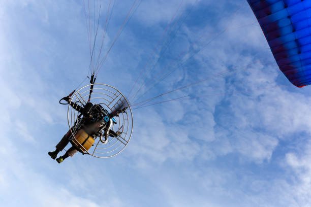 istock Motor paraglider flying in blue sky with white cloud 1067258458
