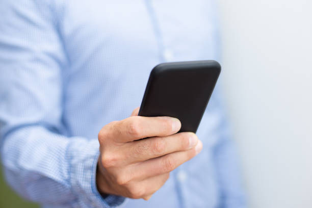 istock Closeup of man holding and using smartphone 1067262156