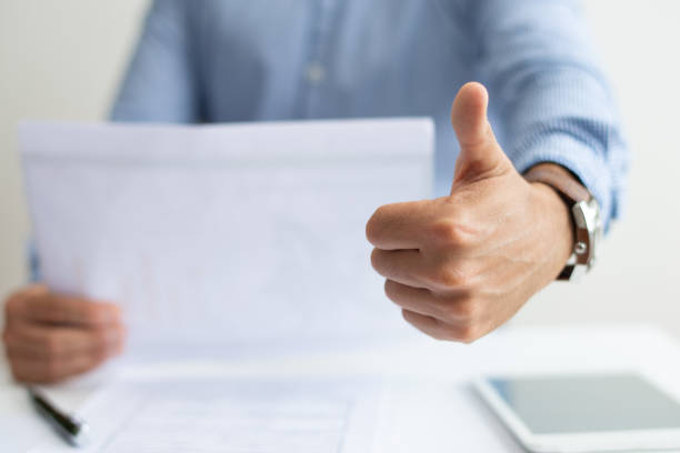 istock Closeup of man holding document and showing thumb up 1067263280
