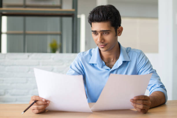 istock Concentrated male manager attentively viewing document 1067269174