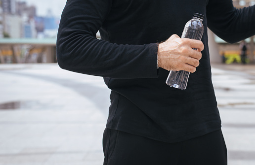 Man hands holding and drink water from bottle after wake up,Concept of good health,close up