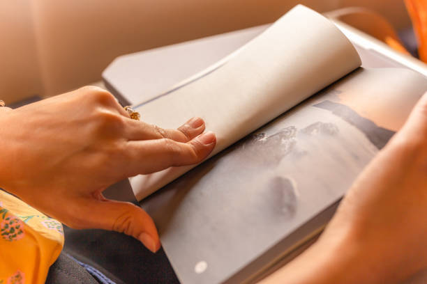 Woman passenger killing time by reading book while traveling on the plane