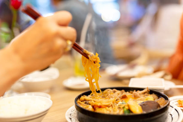 istock Hand with chopsticks eating Japanese udon noodles. 1067275208