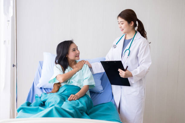 hands woman doctor reassuring her female patient in hospital room,doctor giving a consultation and encouragement to patient - healthcare and medicine nurse doctor general practitioner imagens e fotografias de stock