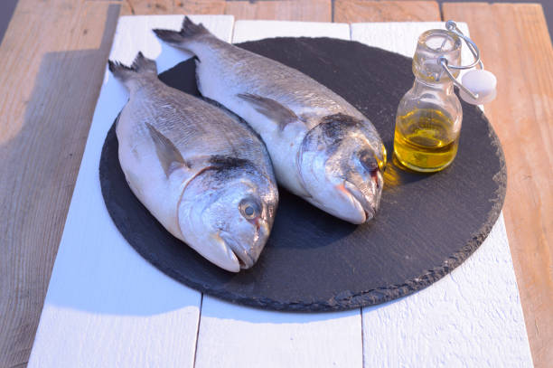 istock dorado fish on a black plate with olive oil bottle 1067281436