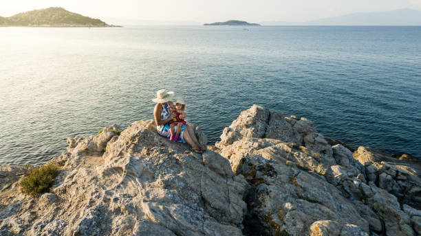 istock Mother and daughter on rocky coastline 1067287454