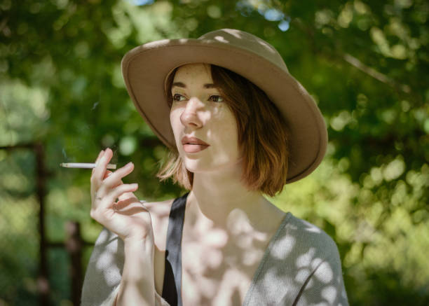 istock Woman wearing in hat and poncho smokes. 1067292506