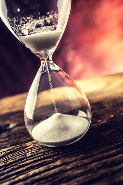 istock Modern hourglass in running time on wooden table. 1067294810