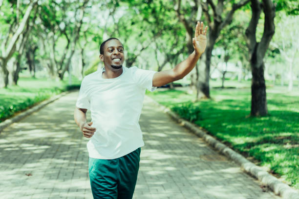 istock Friendly sporty black guy jogging in city park 1067294882