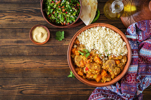 Traditional tajine dishes, couscous  and fresh salad  on rustic wooden table. Tagine lamb meat and pumpkin. Top view. Flat lay Traditional tajine dishes, couscous  and fresh salad  on rustic wooden table. Tagine lamb meat and pumpkin. Top view. Flat lay tajine stock pictures, royalty-free photos & images