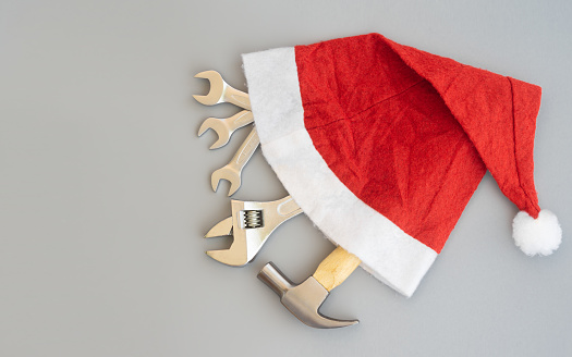 Hammer, adjustable wrench, wrenches in Santa Hat. Handy tools in Christmas festival background concept.