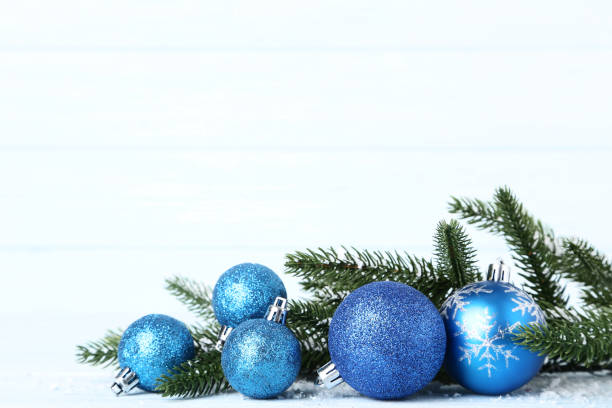 istock Blue christmas baubles with fir tree branches on wooden table 1067305782