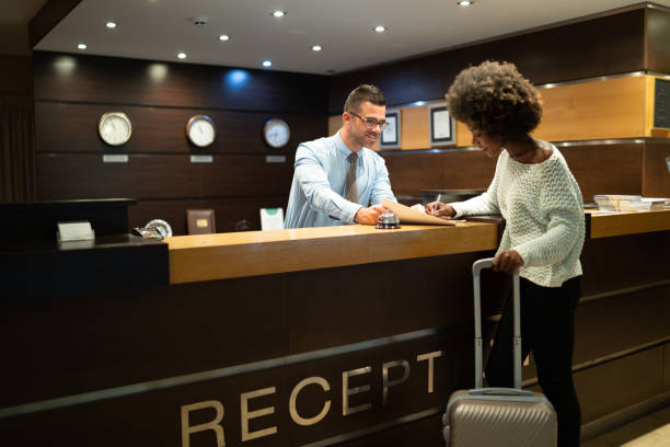 registre de touristes dans l’hôtel - hotel receptionist photos et images de collection