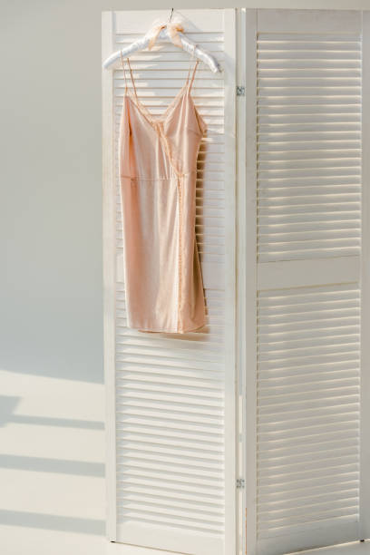 istock silk nightie with lace hanging on white room divider 1067316904