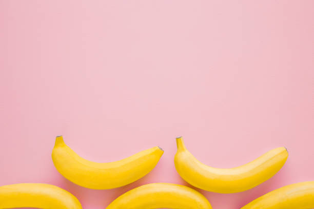 istock Beautiful, fresh, yellow bananas on pastel pink background. Mockup for different ideas. Empty place for text, quote or logo. Top view. 1067325742