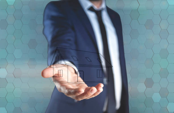 istock young man hand house model in screen 1067327202