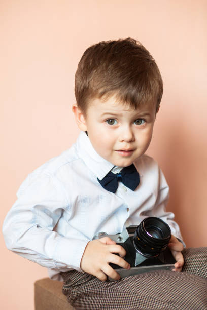 istock Little boy with aged retro camera. Child with an old camera 1067328174